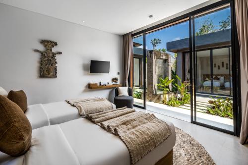 een woonkamer met een witte bank en een groot raam bij Villa Jimeste by BaliSuperHost in Ubud