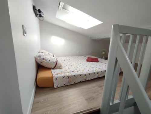 Un pequeño dormitorio con una cama y una escalera en La Maison Libourne, 4 pers, Hypercentre, rue calme, en Libourne