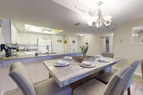 a kitchen with a dining table with chairs and a counter at 210 - Sandy Shores in St. Pete Beach