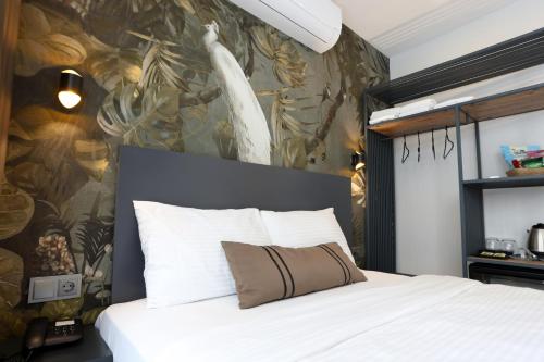 イズミールにあるRiva Hotel Alsancakの白いベッド1台付きのベッドルーム1室(壁に絵画付)