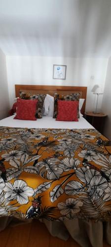a bedroom with a bed with a comforter on it at Le Tournesol in La Saline les Bains