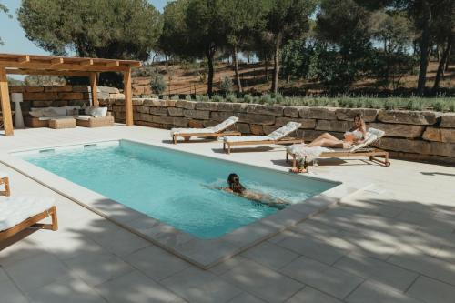 a woman laying in a swimming pool in a backyard at Casalot Almancil in Almancil