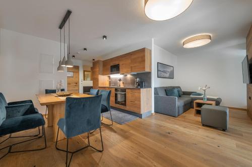 a kitchen and living room with a table and chairs at AlpenParks Hotel & Apartment Carpe Solem Mariapfarr in Mariapfarr
