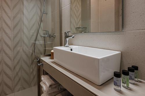 a bathroom with a white sink and a shower at AMINA APARTMENTS in Zakynthos Town