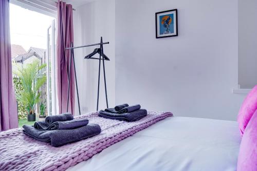 a bed with towels on it with a window at Modern 2 bedroom flat - 15 minutes to Liverpool in Birkenhead