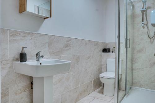 een badkamer met een wastafel en een toilet bij Modern 2 bedroom flat - 15 minutes to Liverpool in Birkenhead