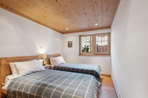 a bedroom with two beds and a window at Chalet Larchwood by Mrs Miggins in Grimentz