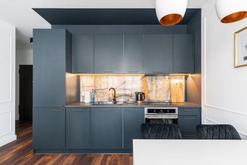 una cucina con armadi blu e piano di lavoro di Rent like home - Grzybowska 85 a Varsavia