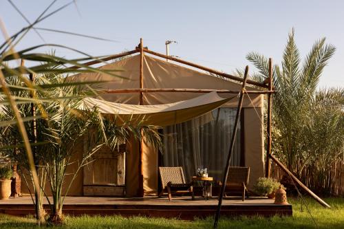 a tent with two chairs and a table at Domaine Des Remparts Hotel & Spa in Marrakech