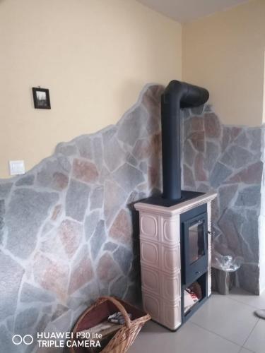 a stove in a room with a stone wall at Silvester Drevenica pod Horou in Vyšná Korňa
