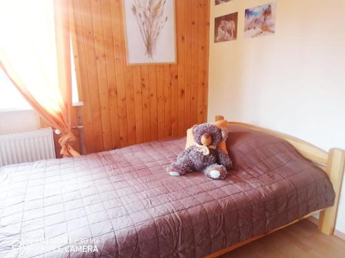 a teddy bear sitting on top of a bed at Silvester Drevenica pod Horou in Vyšná Korňa