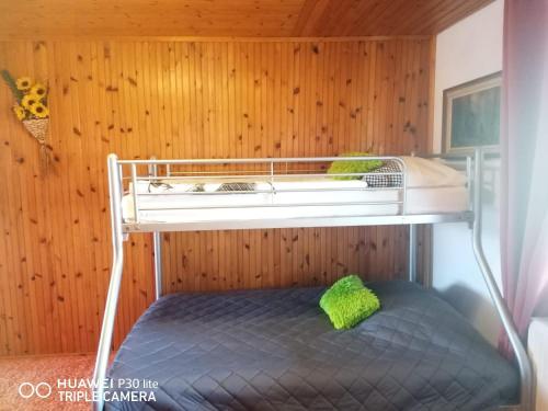 a bunk bed in a room with wooden walls at Silvester Drevenica pod Horou in Vyšná Korňa