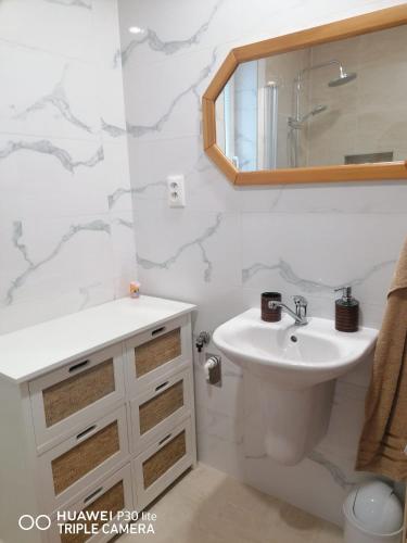 a white bathroom with a sink and a mirror at Silvester Drevenica pod Horou in Vyšná Korňa