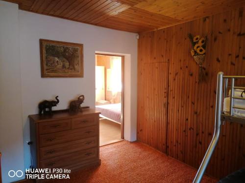 a bedroom with a dresser and a bedroom with a bed at Silvester Drevenica pod Horou in Vyšná Korňa