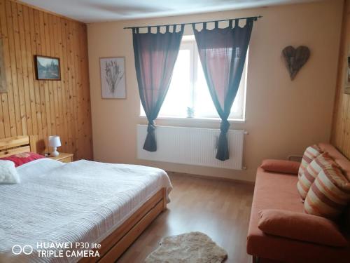a bedroom with a bed and a window at Silvester Drevenica pod Horou in Vyšná Korňa