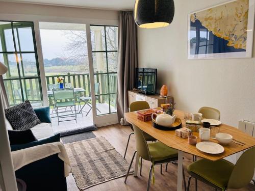 un salon avec une table et des chaises et un balcon dans l'établissement 