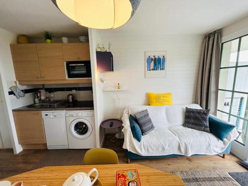 un salon avec un canapé blanc et une cuisine dans l'établissement 