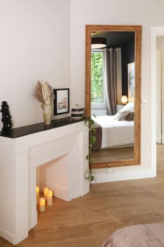 - une chambre avec une cheminée et un miroir dans l'établissement Appartement Le Perchoir by La Boîte En Plus, à Senlis