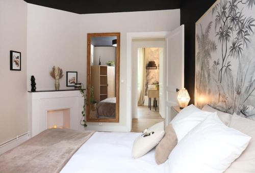 um quarto com uma grande cama branca e um espelho em Appartement Le Perchoir by La Boîte En Plus em Senlis