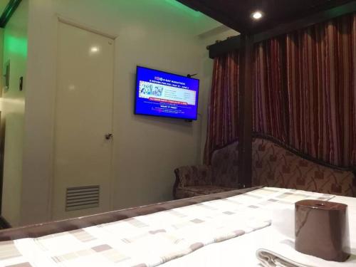 um quarto com uma televisão numa parede com uma mesa em Condo near NAIA Terminals Fasanvej Studio Netflix em Manila