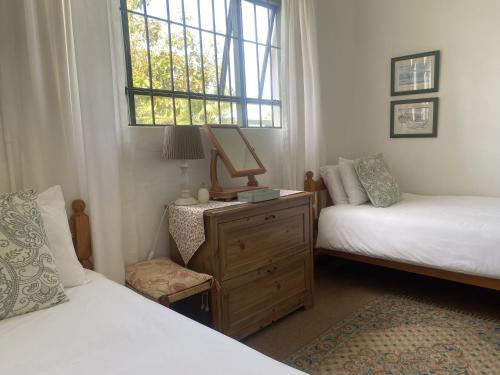 a bedroom with two beds and a dresser and a window at Kingston Farm in Bathurst