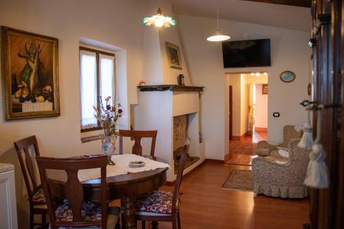 ein Wohnzimmer mit einem Tisch und einem Kamin in der Unterkunft Appartamento storico in Morciano di Romagna
