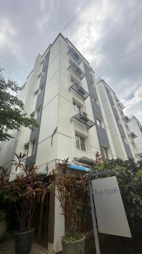 TadaにあるTrue North Apart Hotelの正面に看板がある背の高い白い建物
