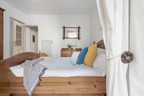 een slaapkamer met een bed met witte lakens en blauwe kussens bij MaCri di TSS' - Per coppie, colazione in balcone, intimo e relax in Levico Terme
