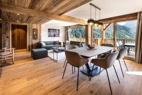 een eetkamer en een woonkamer met een tafel en stoelen bij Résidence Ancolie in Champagny-en-Vanoise