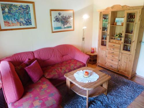 salon z różową kanapą i stołem w obiekcie Holiday Home Tennenbronn-1 by Interhome w mieście Tennenbronn