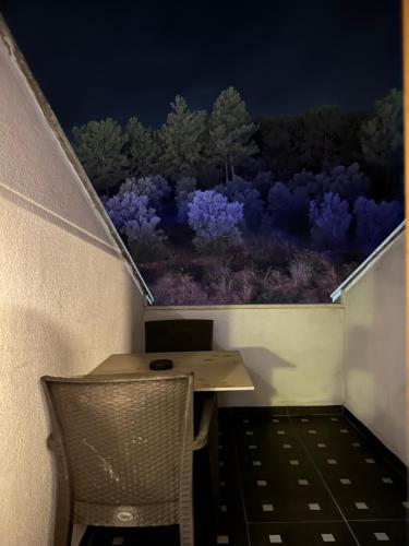 a table and a chair on a balcony at night at Street61 Apart Hotel in Sarigerme
