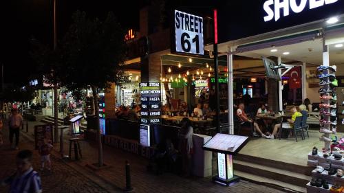 a group of people sitting outside of a restaurant at night at Street61 Apart Hotel in Sarigerme