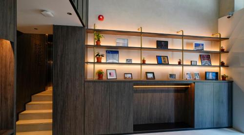 a lobby with a staircase and a wall with shelves at ST Signature Bugis Middle in Singapore