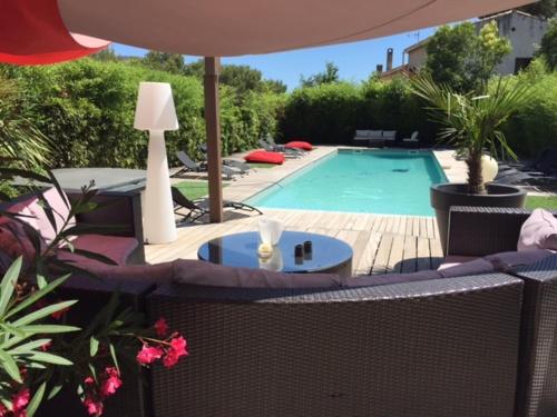 a swimming pool with a table and an umbrella at Villa W in Cassis