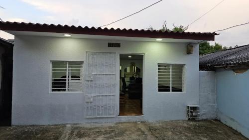 een wit huis met een deur in een tuin bij Casa familiar barranco in Barranquilla