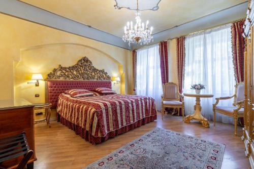 um quarto com uma cama grande e um lustre em Nosticova Apartments em Praga