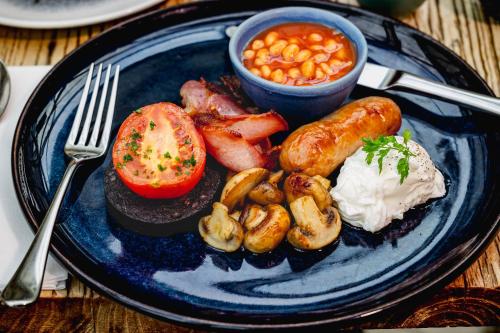 a blue plate with food on a wooden table at The Salutation Inn in Topsham