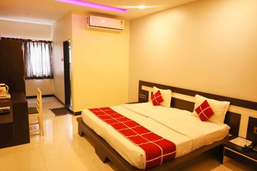 um quarto com uma cama com almofadas vermelhas e brancas em FabHotel Sparkling Pearl em Aurangabad