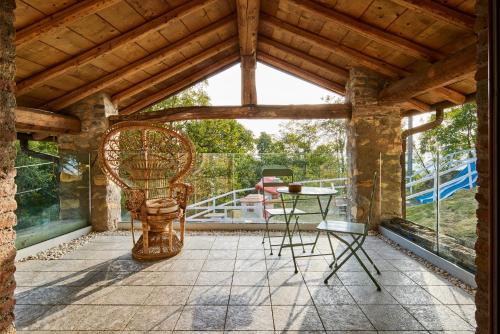 een afgeschermde veranda met een tafel en een stoel bij Agriturismo Cascina Mirandola in Como