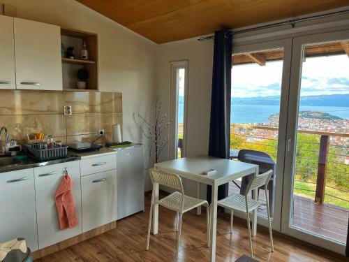 a kitchen with a table and chairs and a balcony at Cityview Unique Apartment Ohrid in Ohrid