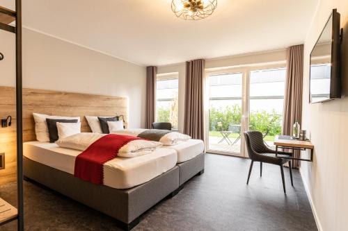 ein Schlafzimmer mit einem großen Bett und einem großen Fenster in der Unterkunft Motel Hasetal in Löningen