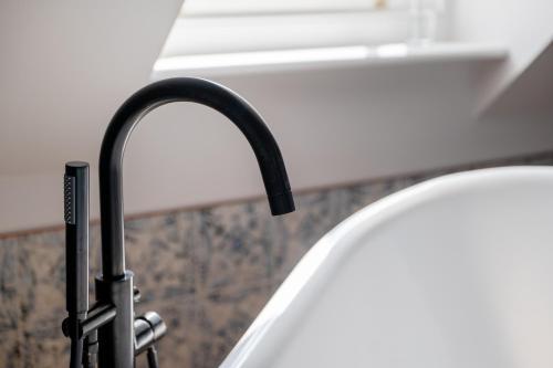 a kitchen sink with a black kitchen faucet at The Sheep and Penguin in Wells