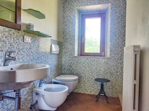 baño con lavabo y aseo y ventana en Agriturismo la Casa del Vecchio Mulino, en Carassai