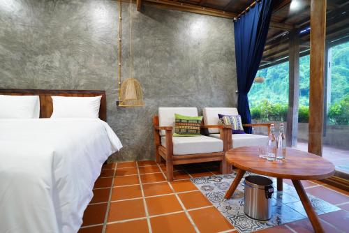 a bedroom with a bed and a table and chairs at Ba Be Jungle Houses in Ba Be