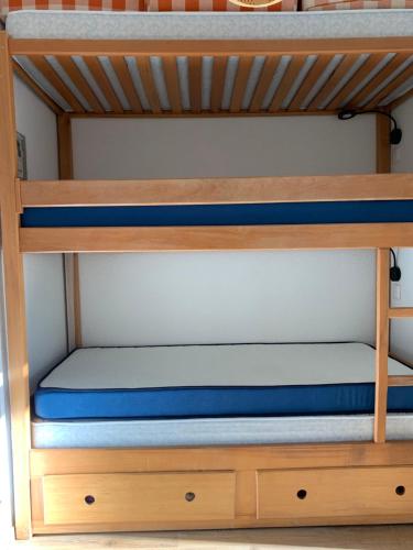 Etagenbett mit blauen Kissen auf dem unteren Etagenbett in der Unterkunft Studio avec Balcon Pra chauvet in Uvernet