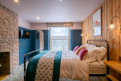 a bedroom with a bed in a room with a fireplace at The Sheep and Penguin in Wells