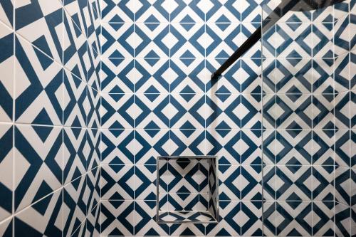 a bathroom with a blue and white tiled wall at The Sheep and Penguin in Wells