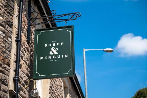 a sign hanging on the side of a building at The Sheep and Penguin in Wells