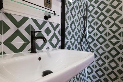 a bathroom with a sink with a f on the wall at The Sheep and Penguin in Wells