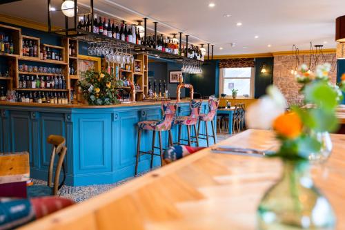 a bar in a restaurant with pink stools at The Sheep and Penguin in Wells